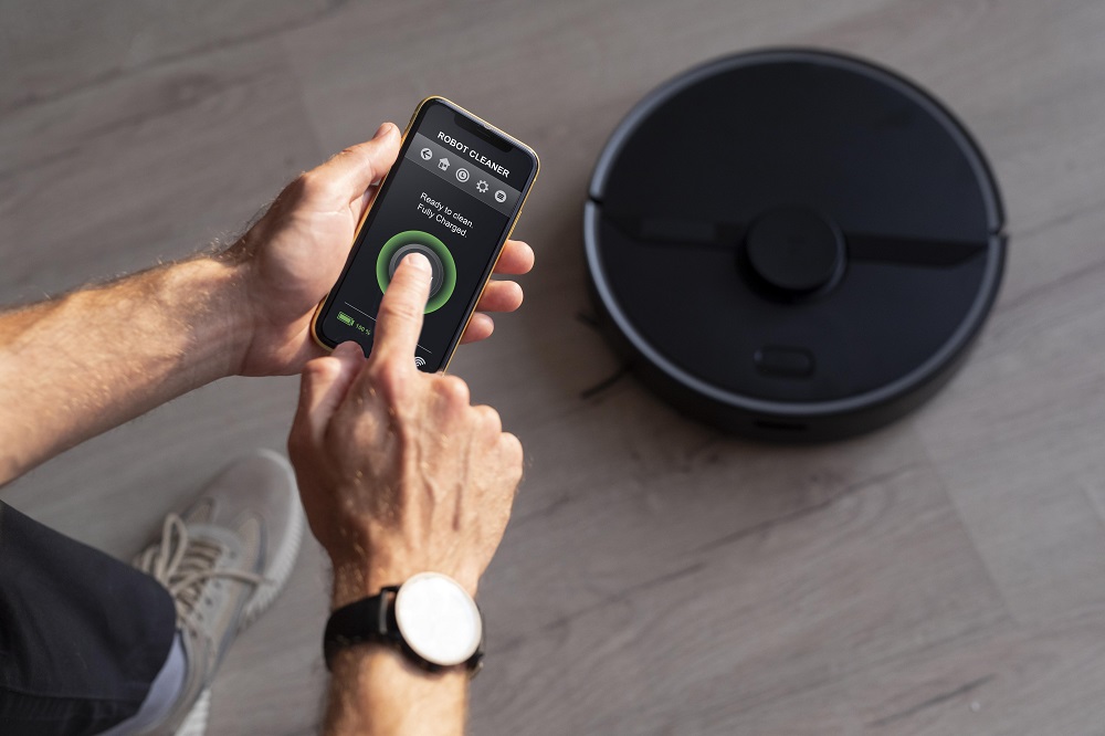 man controlling robot vacuum with his phone